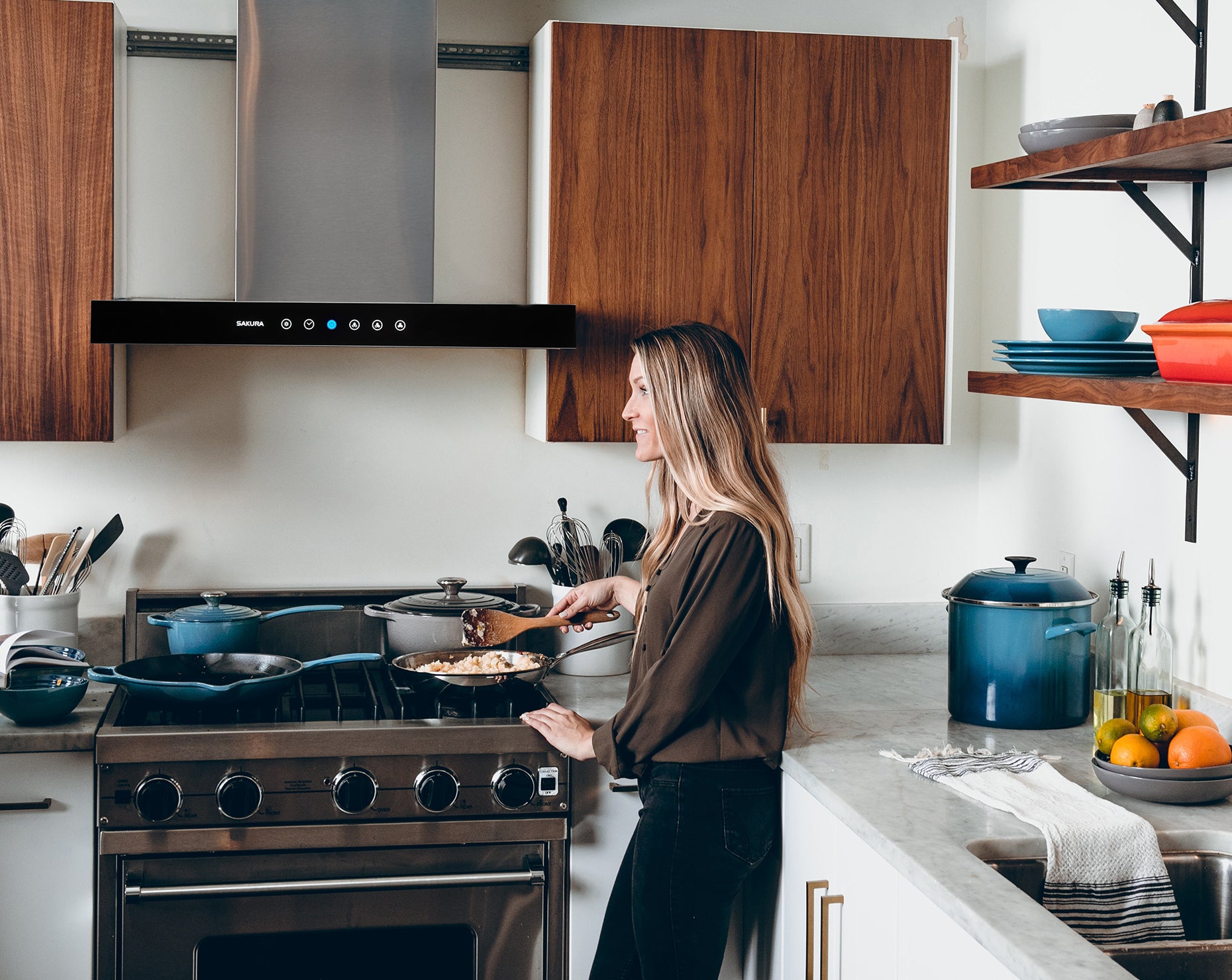 Sleek glass panel range hood easily solving heavy smoke problems in modern American kitchens